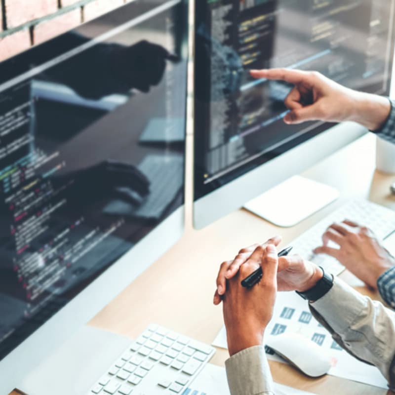hands pointing informatics coding on computer screens