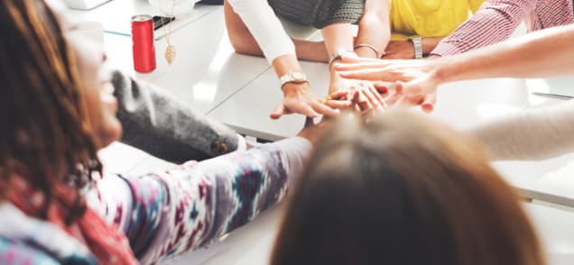 colleagues touching hands in sign of team building